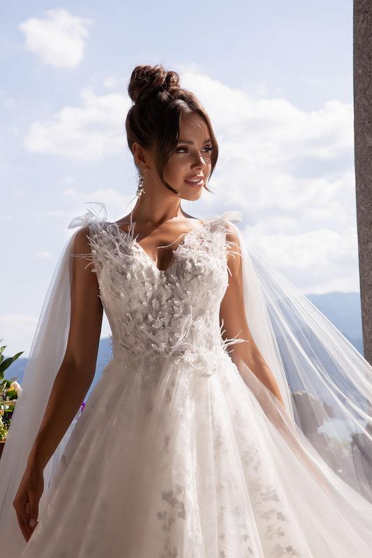 Elegant XAYWEAR wedding dress with floral appliques and sheer tulle veil under bright sky