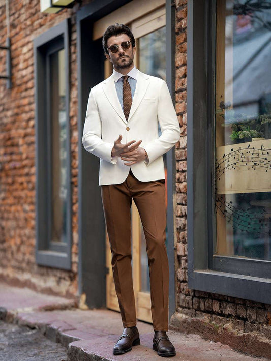 Man wearing a white blazer and brown pants two piece suit for men by XAYWEAR standing outdoors