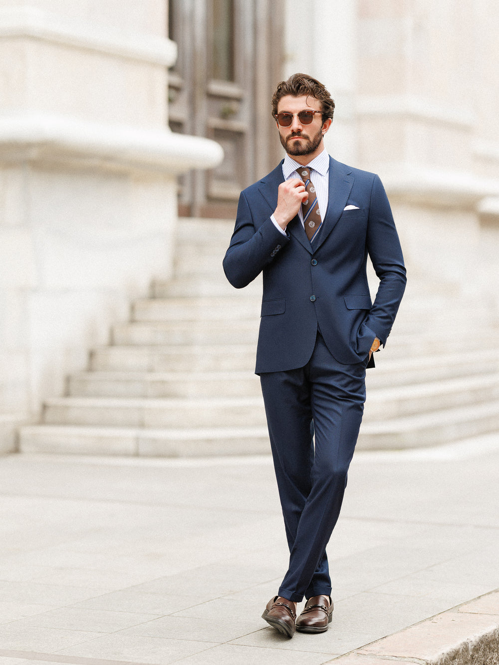 XAYWEAR navy blue formal wedding suit worn by man with brown tie and sunglasses outdoors
