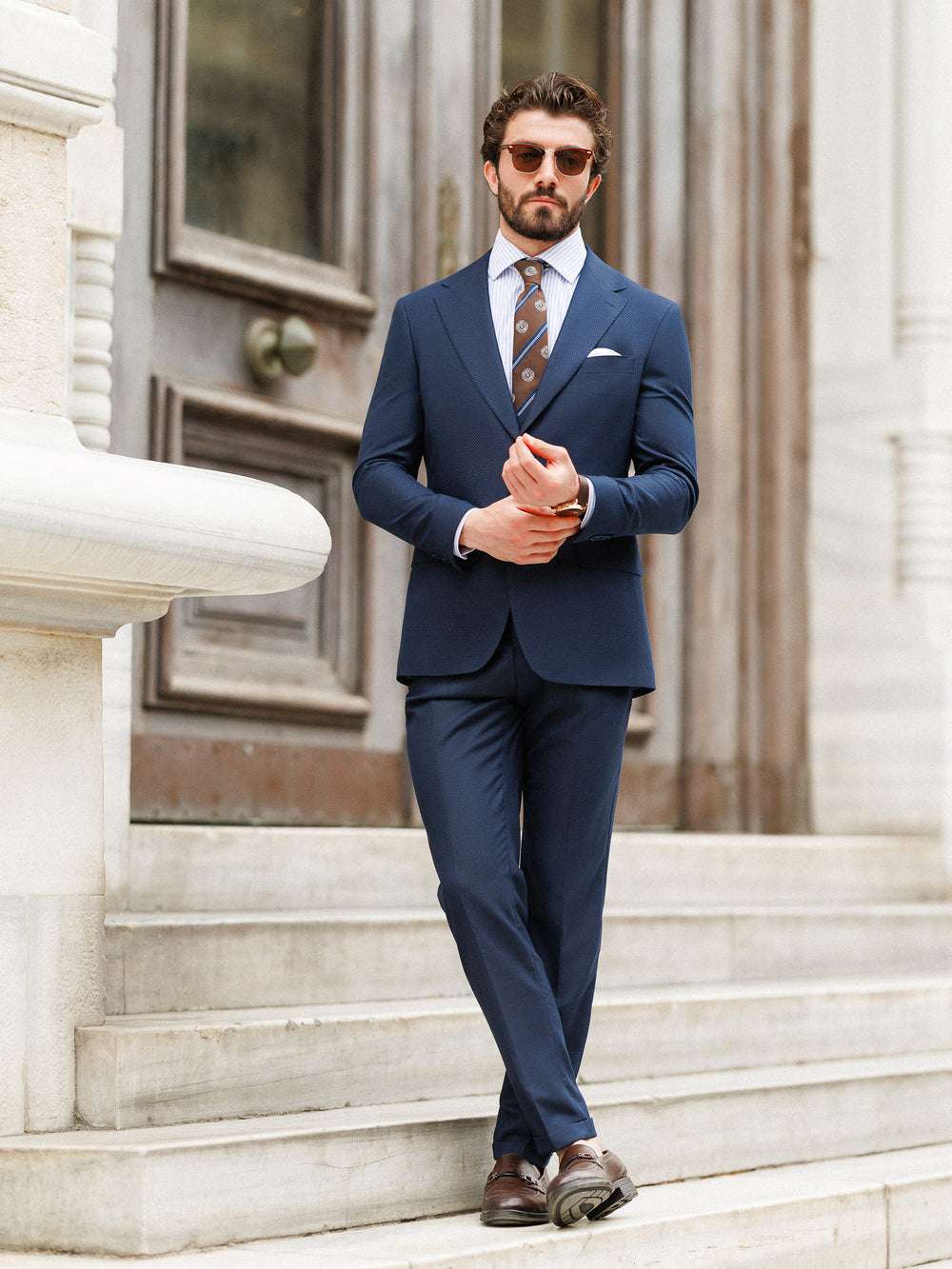 XAYWEAR navy blue formal wedding suit worn by man with sunglasses and brown shoes on steps