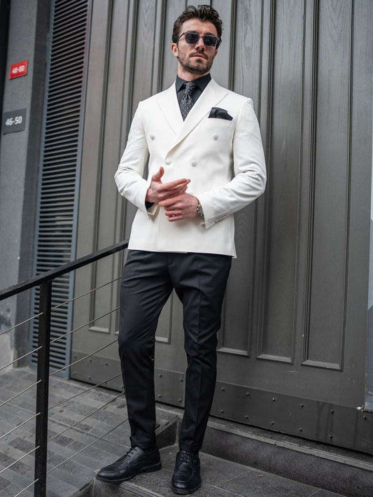 Stylish man in an ivory double breasted tuxedo paired with black pants and sunglasses