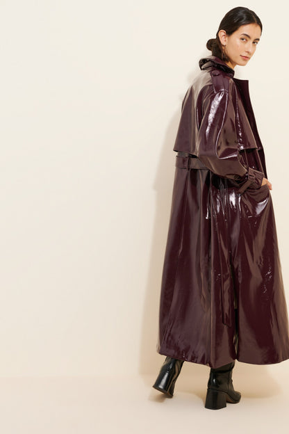XAYWEAR shiny dark leather coat for women with belted waist and long silhouette