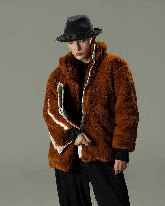 Model wearing a luxurious faux fur jacket in brown, styled for a chic winter look