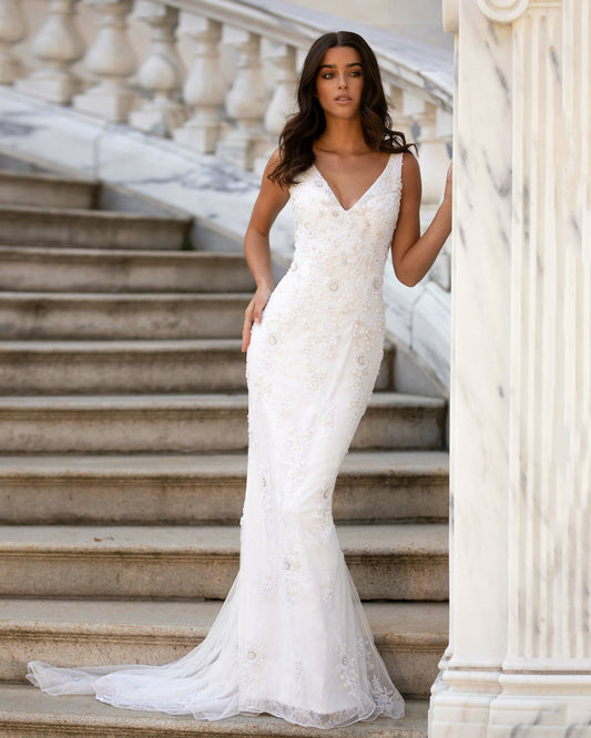 Elegant model showcasing a luxurious mermaid wedding dress with intricate beading and a stunning train