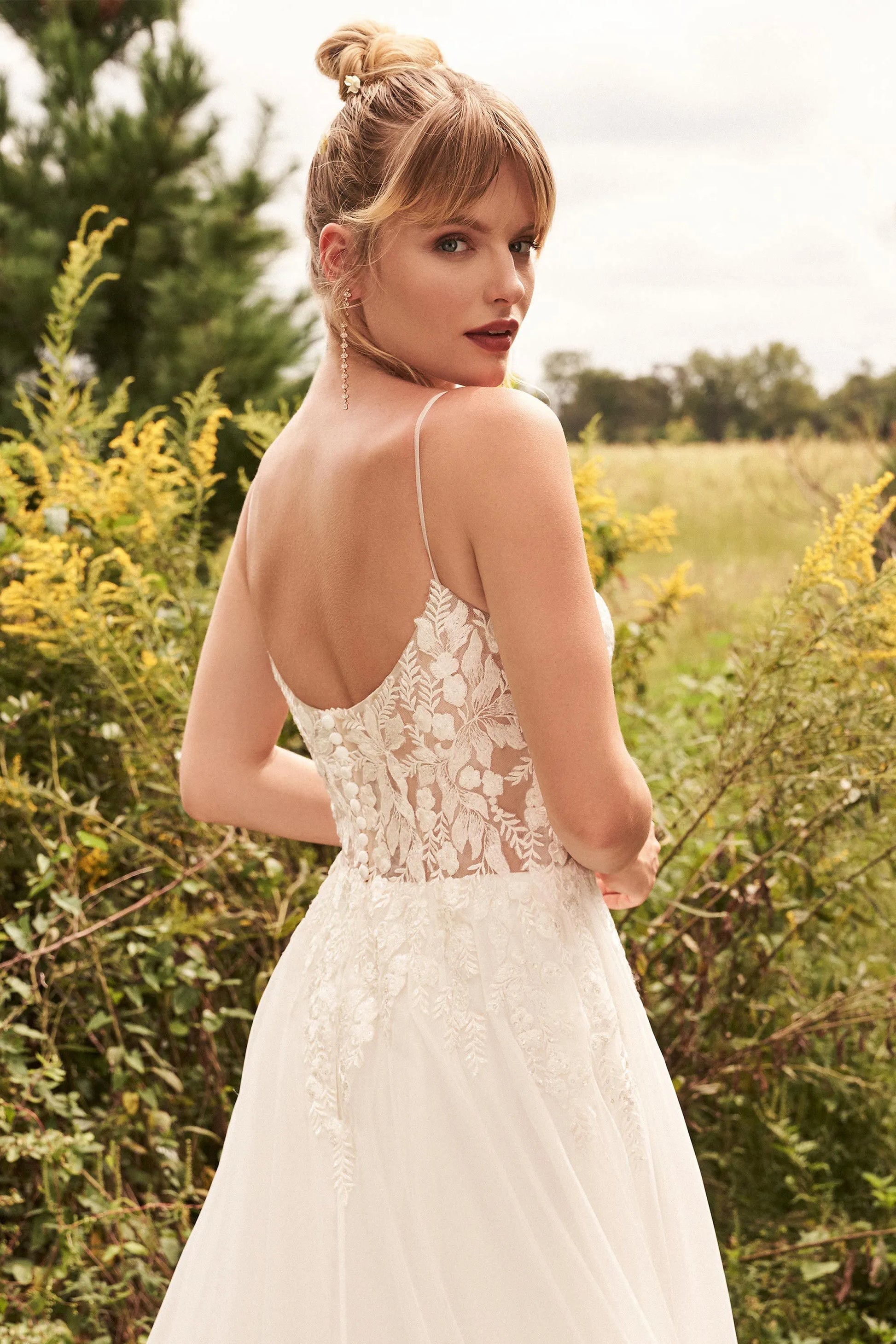 XAYWEAR luxury wedding dress featuring sheer lace back and delicate spaghetti straps in outdoor setting