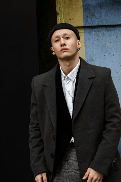 XAYWEAR men coat in dark gray worn over white shirt and black sweater with plaid pants