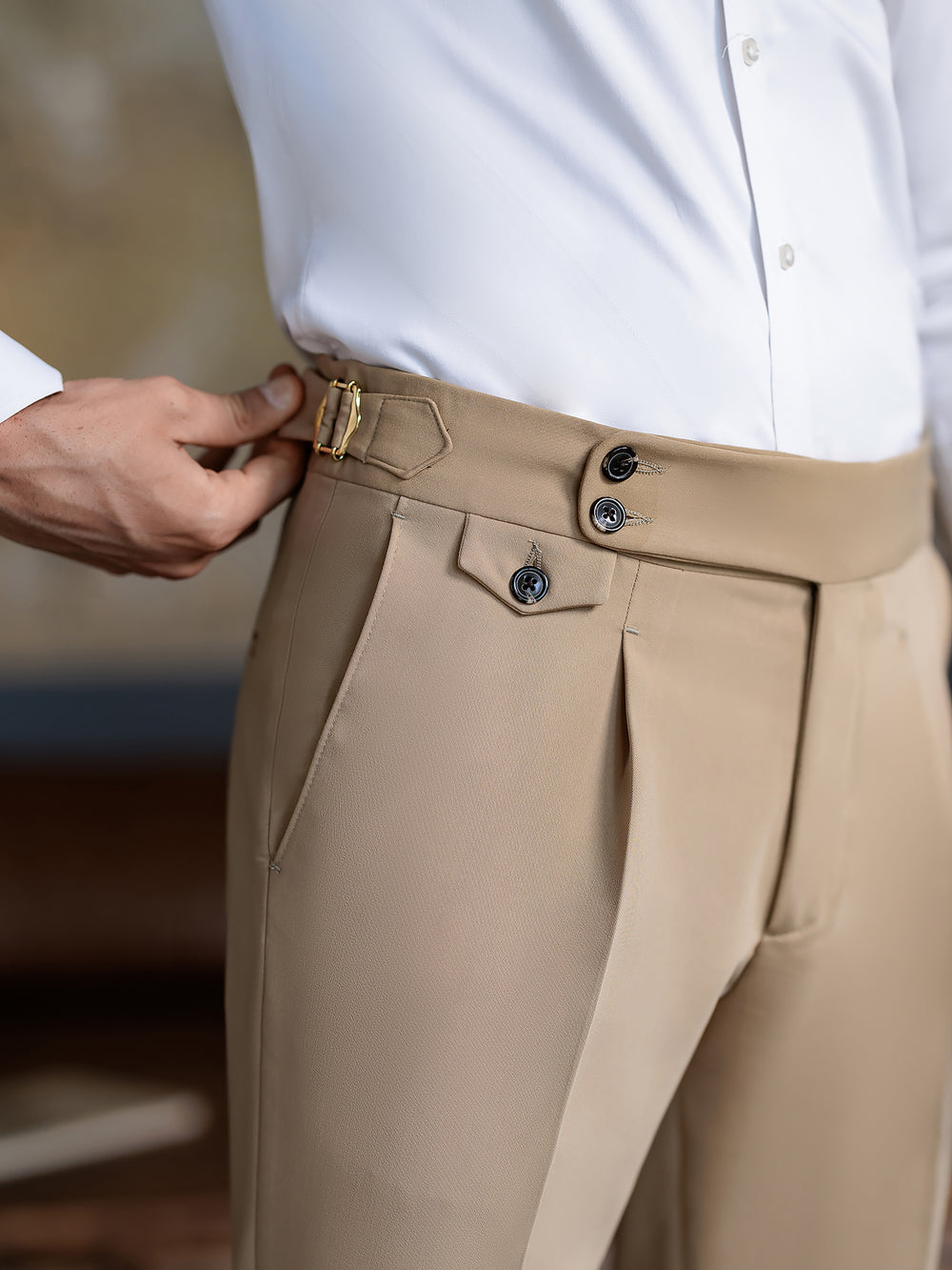 Close-up of beige suit pants for men from XAYWEAR with adjustable waistband and button details