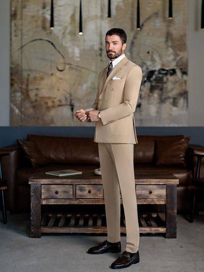 Man wearing beige double-breasted suit for men by XAYWEAR standing in modern living room