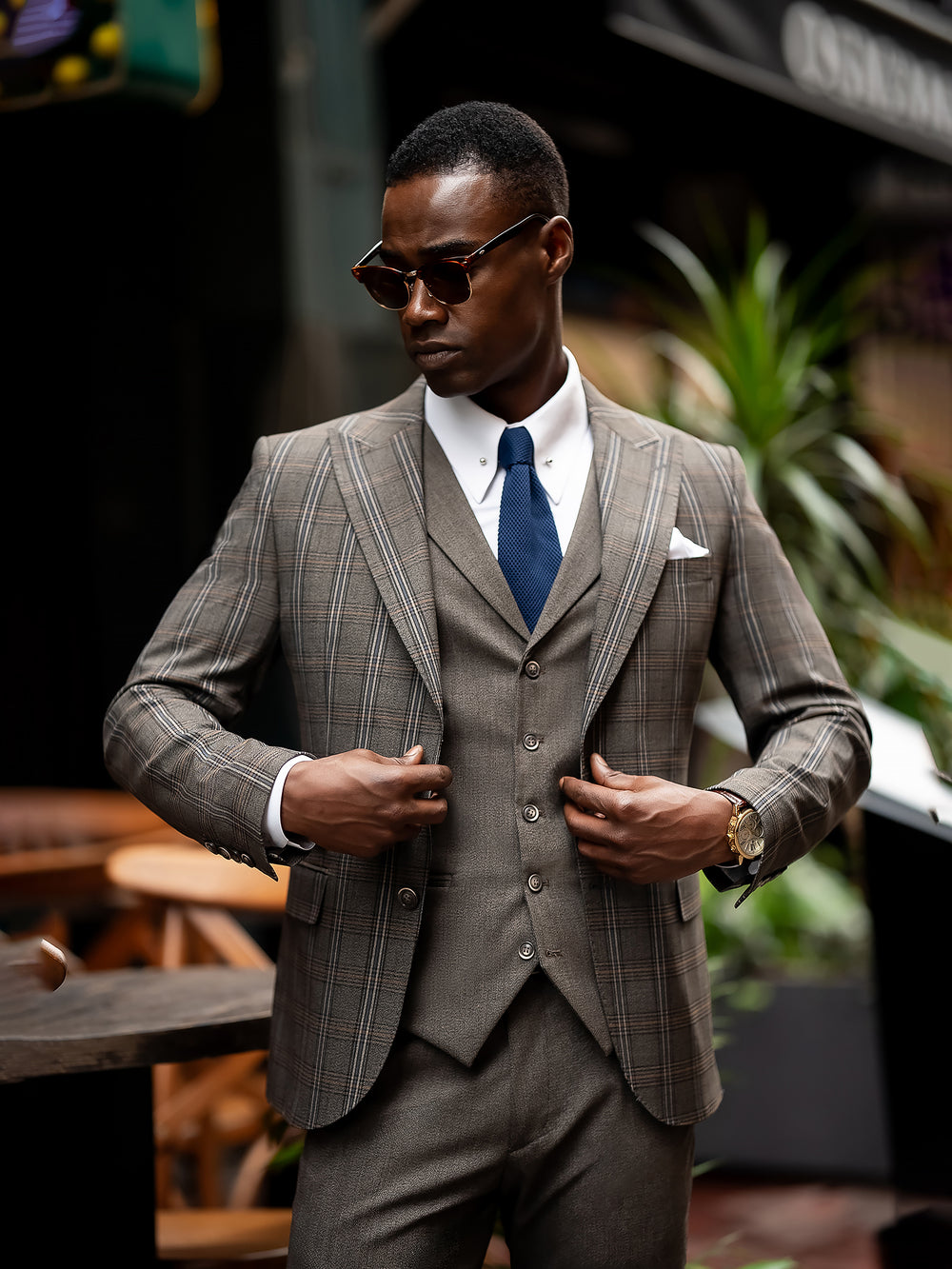 XAYWEAR stylish men suit with plaid pattern worn with white shirt and blue tie outdoors