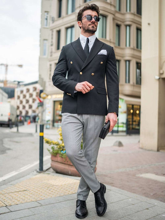 Elegant modern double-breasted blazer in black, styled with gray trousers and accessories for a chic look