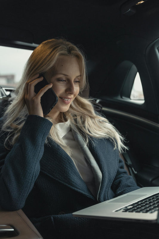 XAYWEAR stylish overcoat worn by a woman on a phone call in a car with a laptop