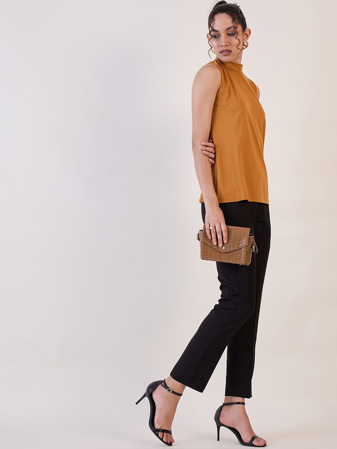 XAYWEAR high neck sleeveless top in brown paired with black pants and black heels