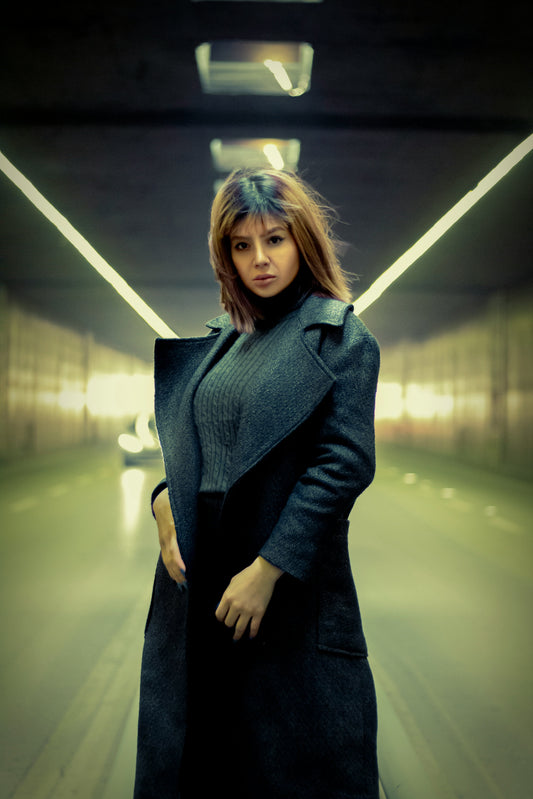 Fashionable model wearing a XAYWEAR Premium Long Coat in a modern tunnel setting