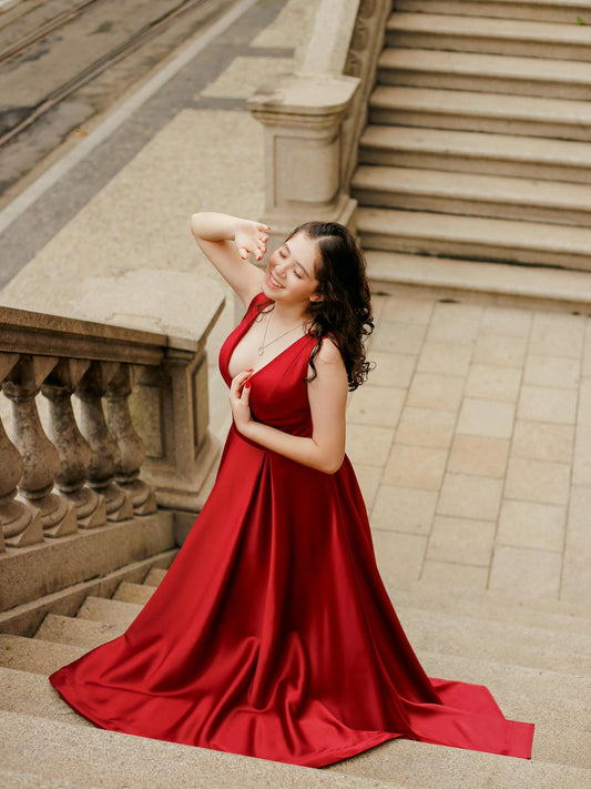 Elegant red XAYWEAR premium satin evening wear gown flowing down a staircase