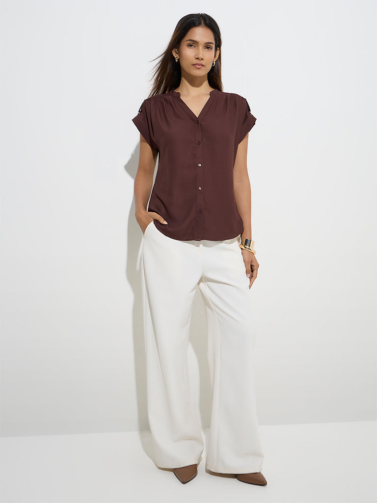 XAYWEAR relaxed fit short sleeve top in burgundy paired with stylish white wide-leg pants