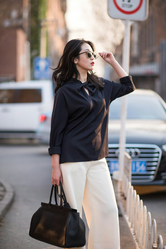 Stylish women outfit by XAYWEAR featuring black top and white pants with black handbag and sunglasses