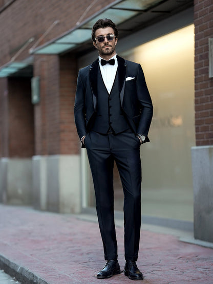XAYWEAR elegant black three piece suit with bow tie and sunglasses worn by man outdoors