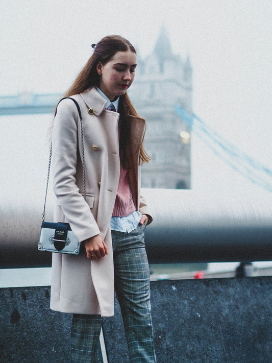 XAYWEAR beige trench coat for women worn with pink sweater and plaid pants outdoors