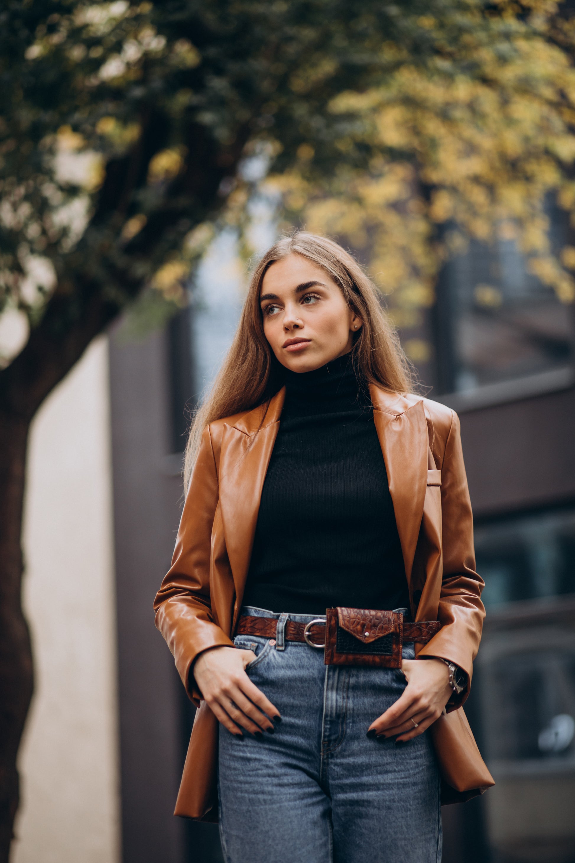 XAYWEAR faux leather jacket for women in brown worn with black turtleneck and jeans outdoors
