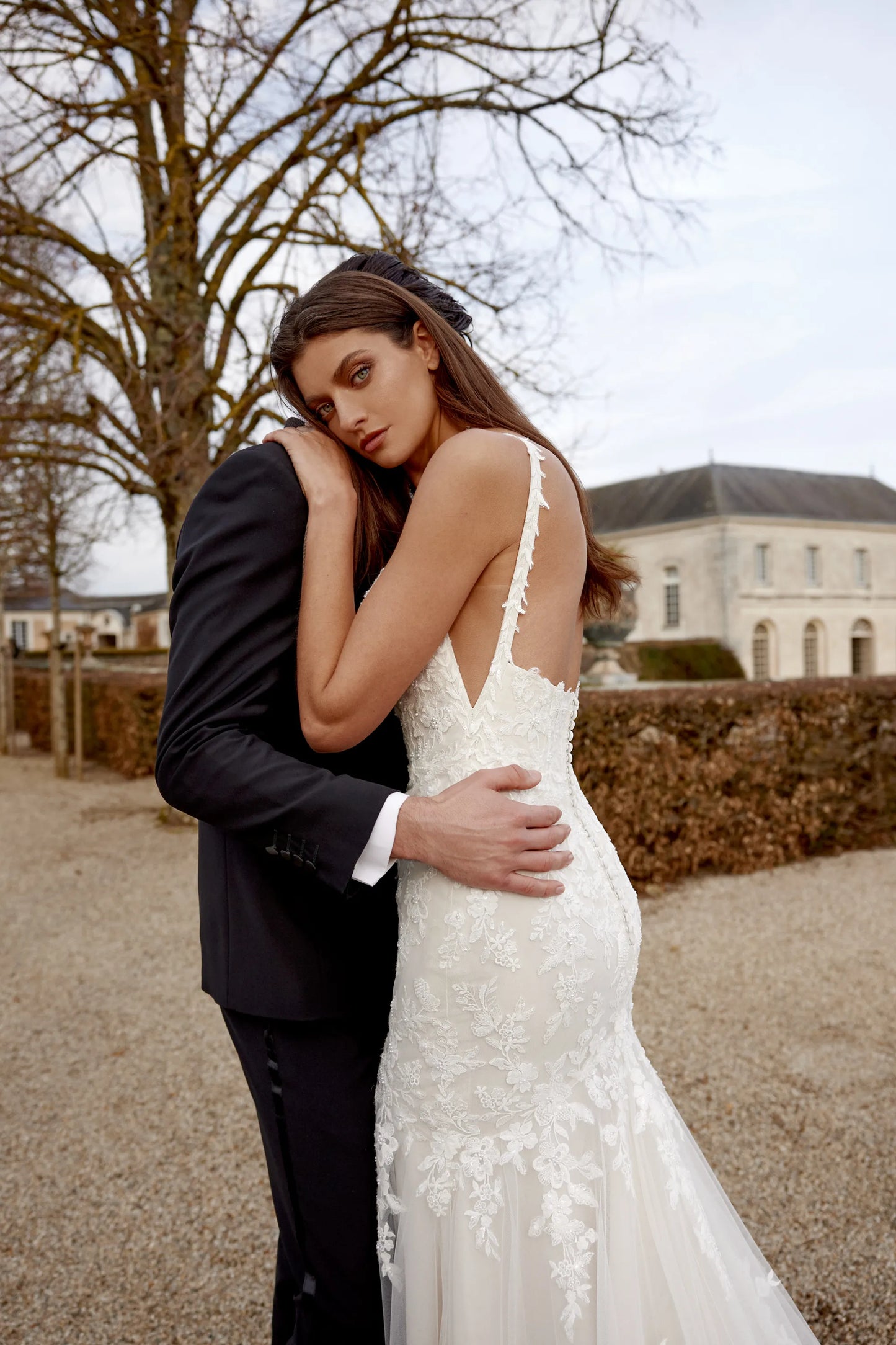 XAYWEAR wedding dress with lace details and deep back worn outdoors with groom in black suit