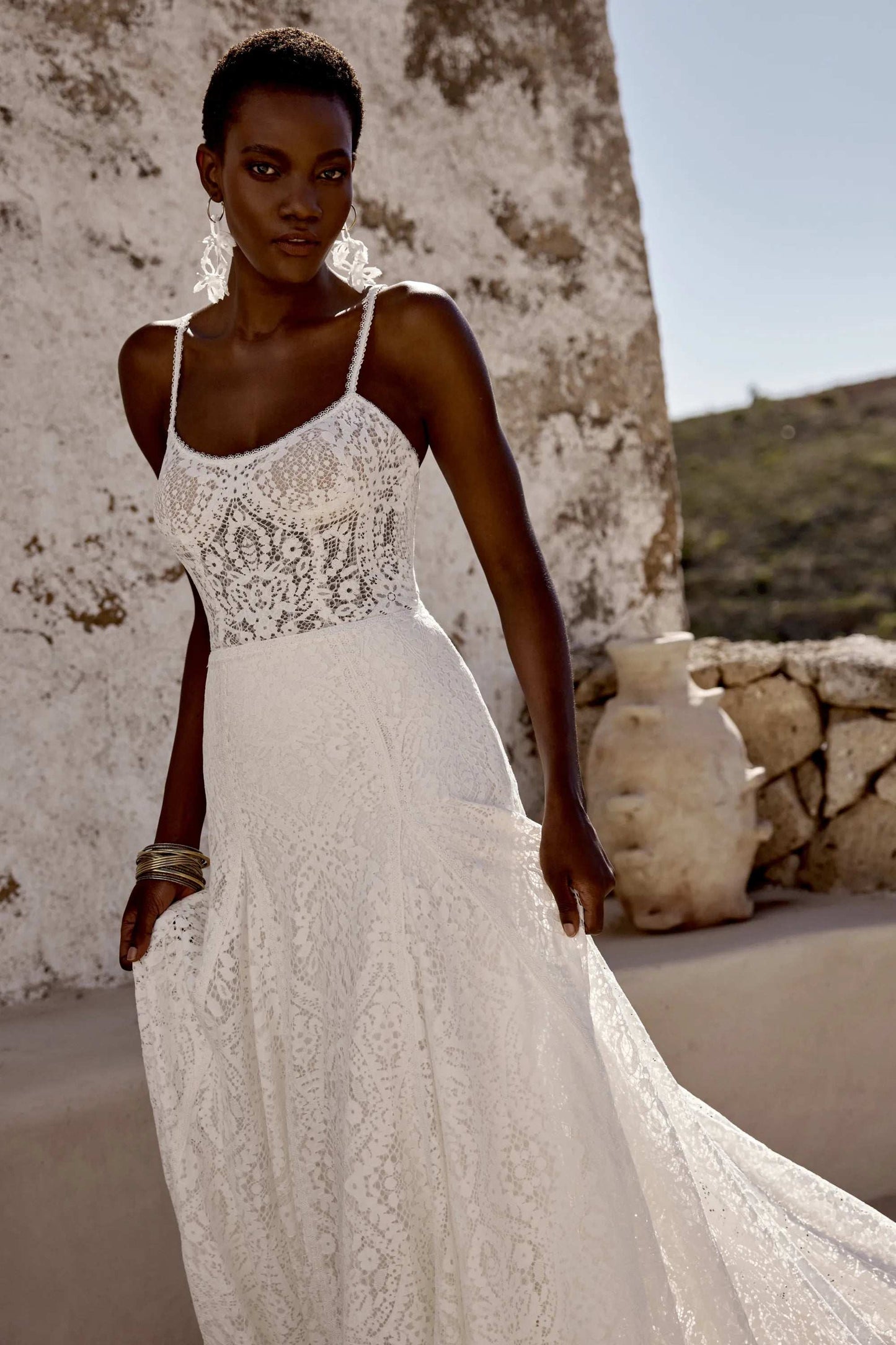 Elegant white lace wedding gown by XAYWEAR with delicate straps and flowing skirt