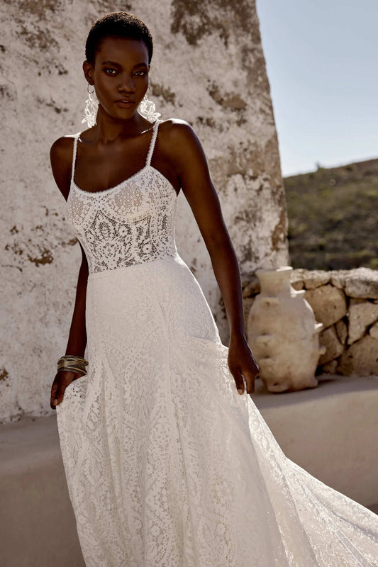 Elegant white lace wedding gown by XAYWEAR with delicate straps and flowing skirt