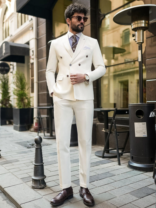 Man wearing a stylish white suit for men by XAYWEAR with brown shoes and sunglasses outdoors