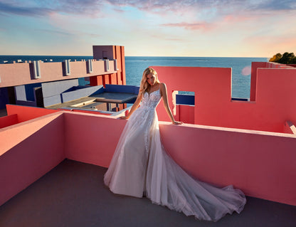XAYWEAR white wedding dress gown with lace bodice and long flowing train on model by pink terrace
