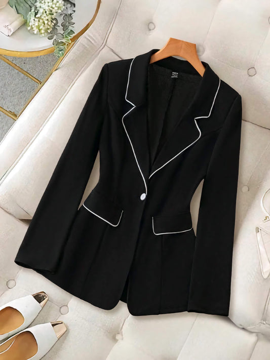 XAYWEAR women black suit set featuring a tailored blazer with white piping detail on a white couch