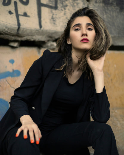 XAYWEAR black women blazer worn by model sitting outdoors with casual urban background
