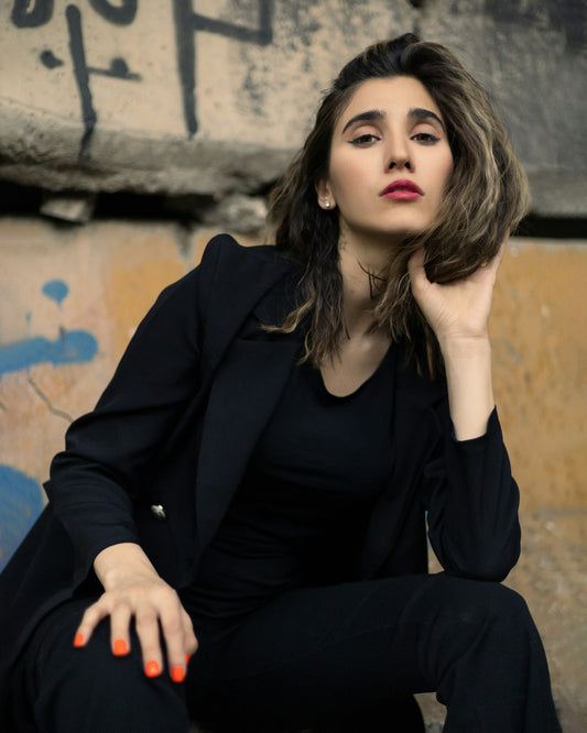 XAYWEAR black women blazer worn by model sitting outdoors with casual urban background