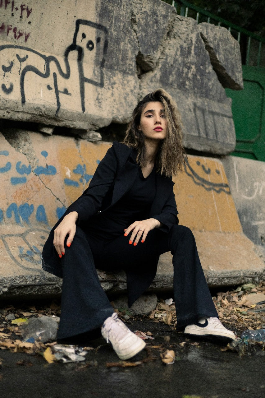 XAYWEAR black women blazer worn by model posing outdoors near graffiti wall