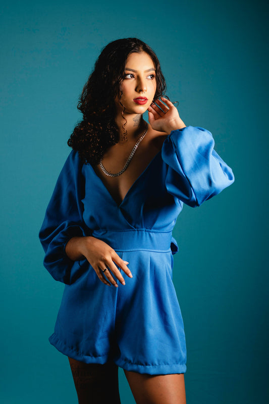 XAYWEAR women blue jumpsuit with long puff sleeves and deep V neckline styled by model
