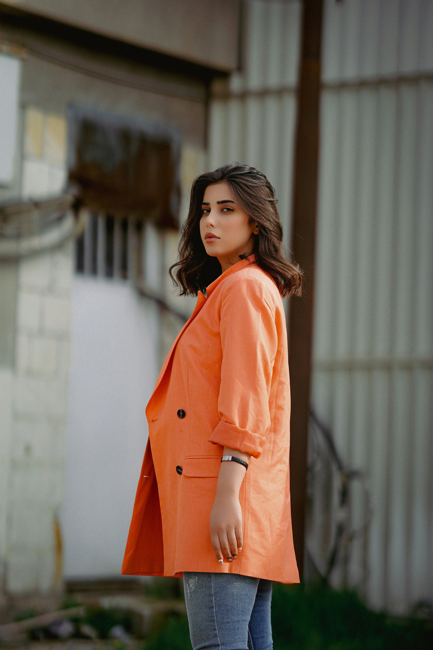 XAYWEAR bright orange blazer styled as a women coat with button details and rolled sleeves