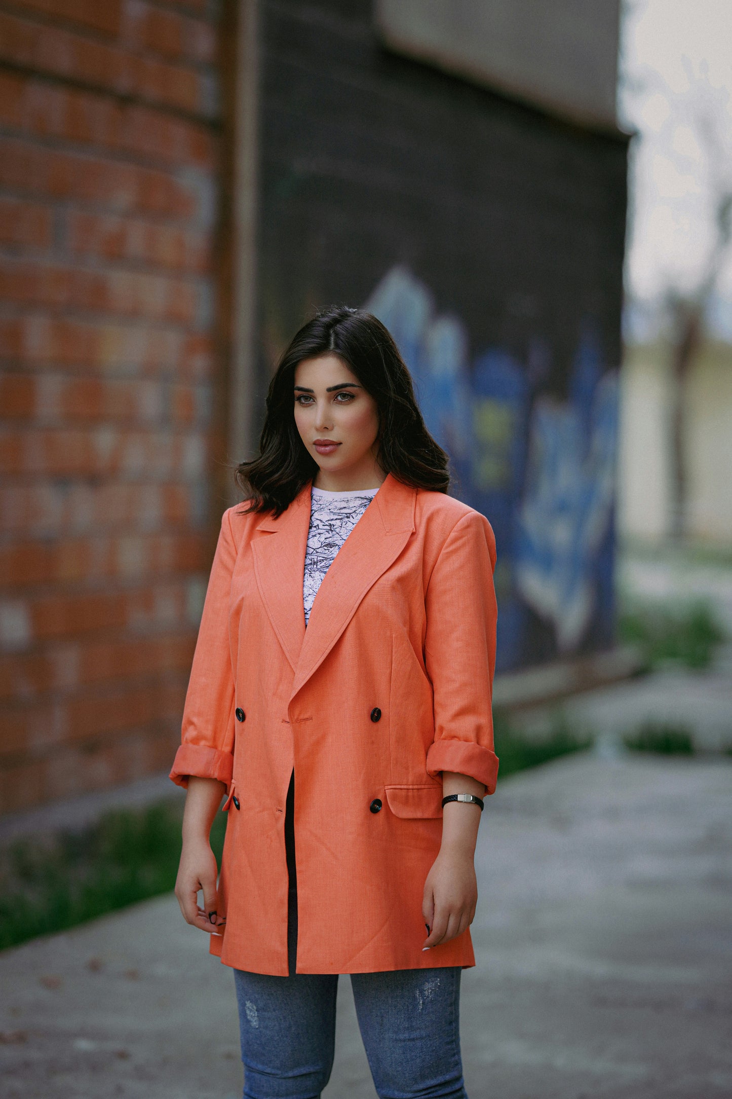 XAYWEAR orange blazer styled as a women coat with black buttons and rolled sleeves