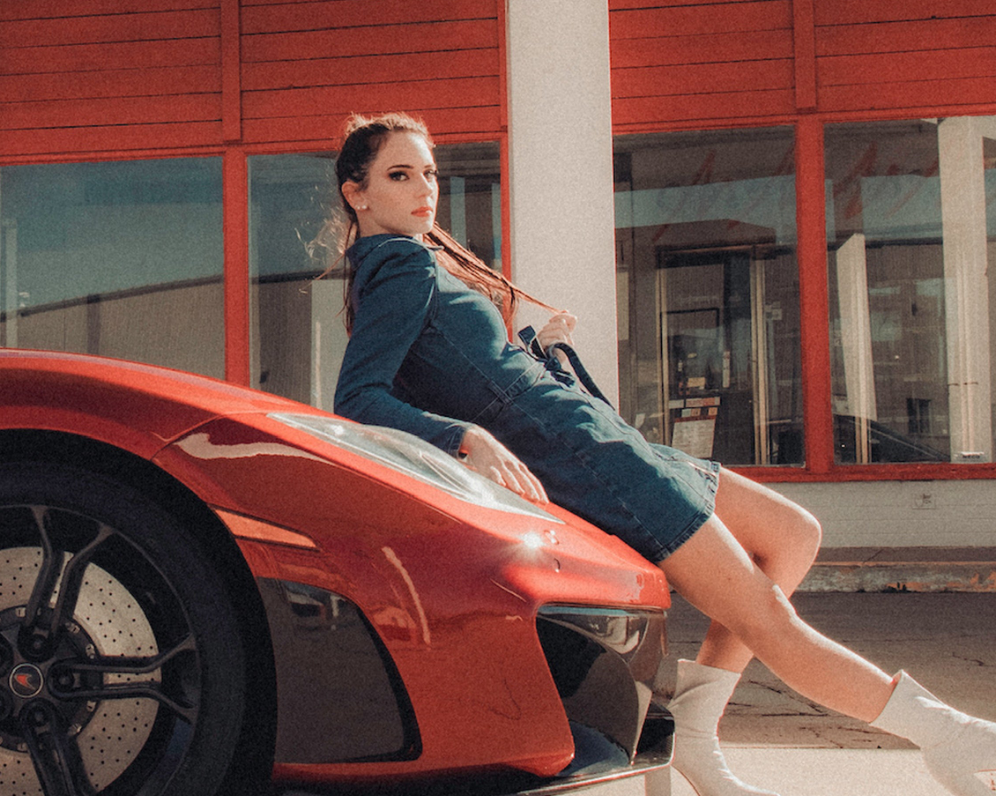 Woman wearing women denim midi dress by XAYWEAR leaning on red sports car outdoors