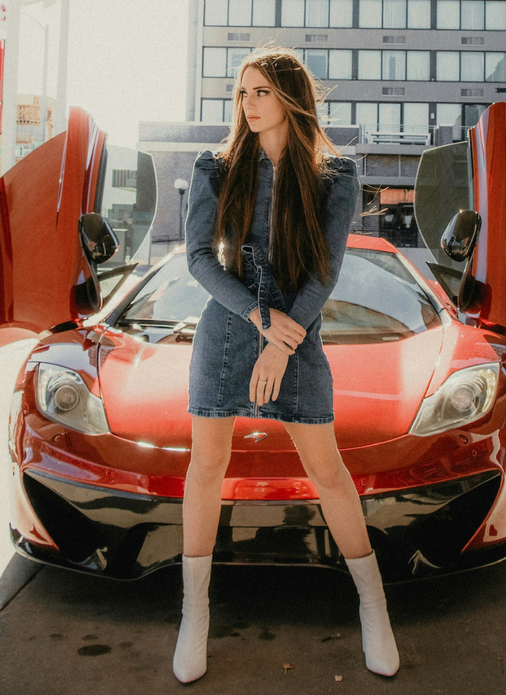 Woman wearing XAYWEAR women denim midi dress standing in front of a red sports car with gullwing doors