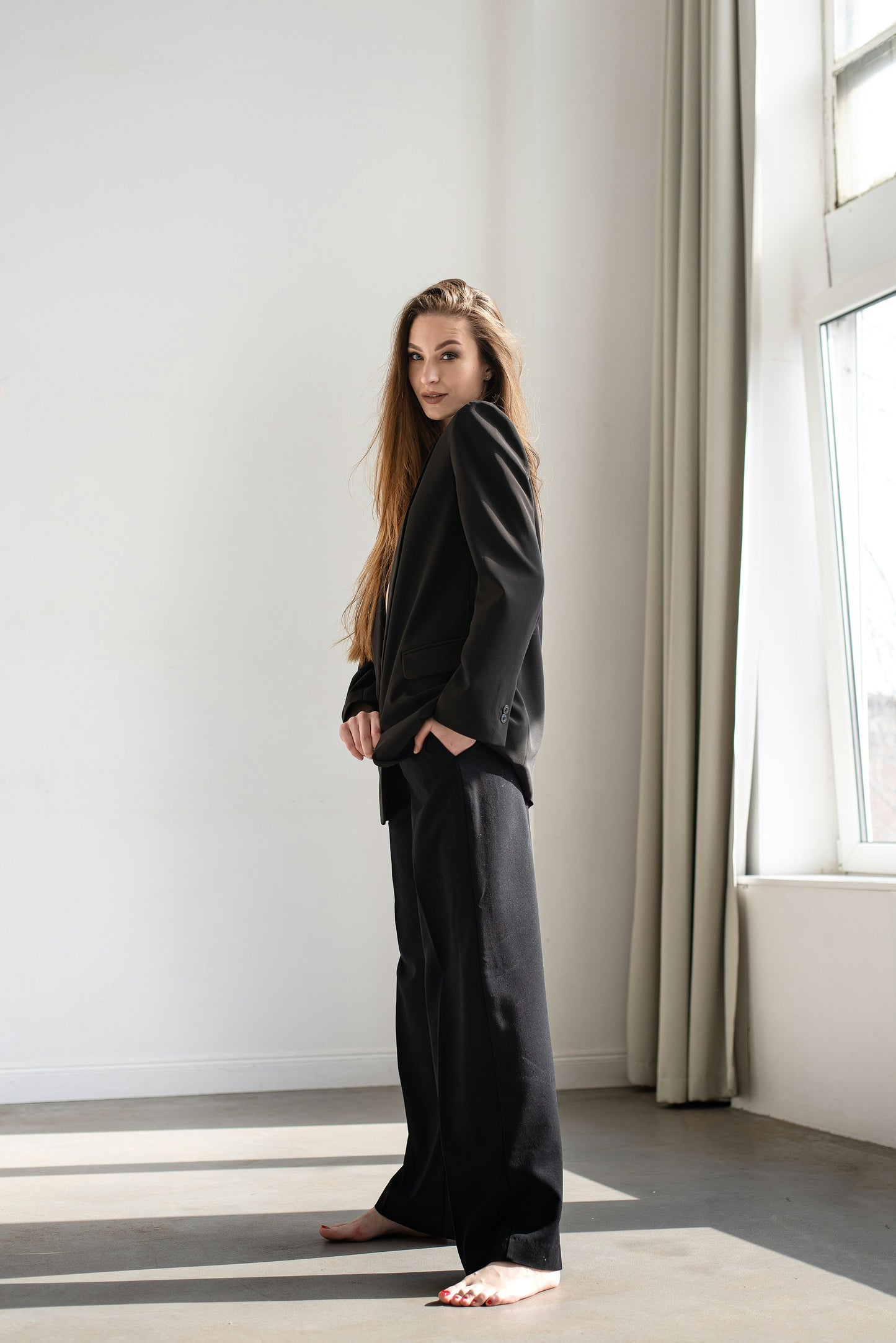 XAYWEAR black suit worn by woman standing barefoot near window showcasing women formal attire