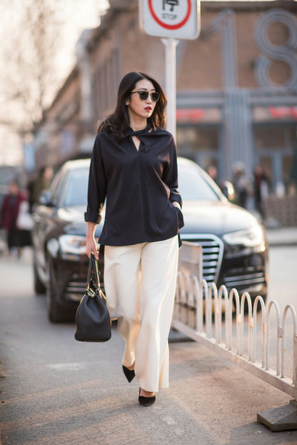 Stylish women outfit by XAYWEAR featuring a black top and white wide-leg pants with handbag