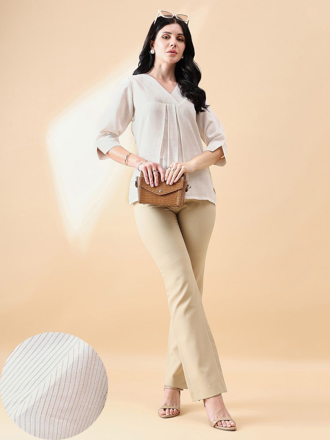 XAYWEAR women outfit featuring a white blouse with pleats and beige pants paired with sandals and a brown clutch